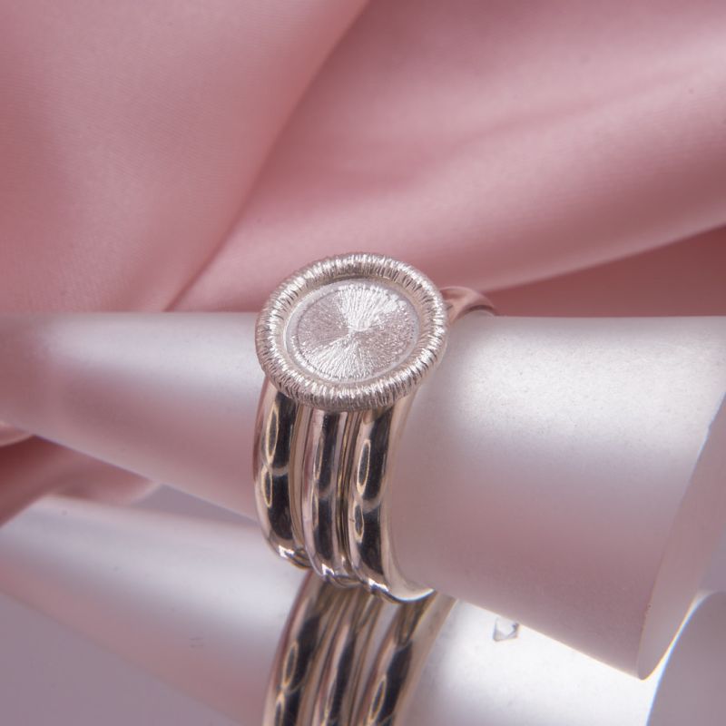 Dreiteiliges Schmuck-Set aus Sterling Silber mit dem gefrästen Coletta Facet Ring zwischen zwei spiegelglatten Clara Stapelringen.